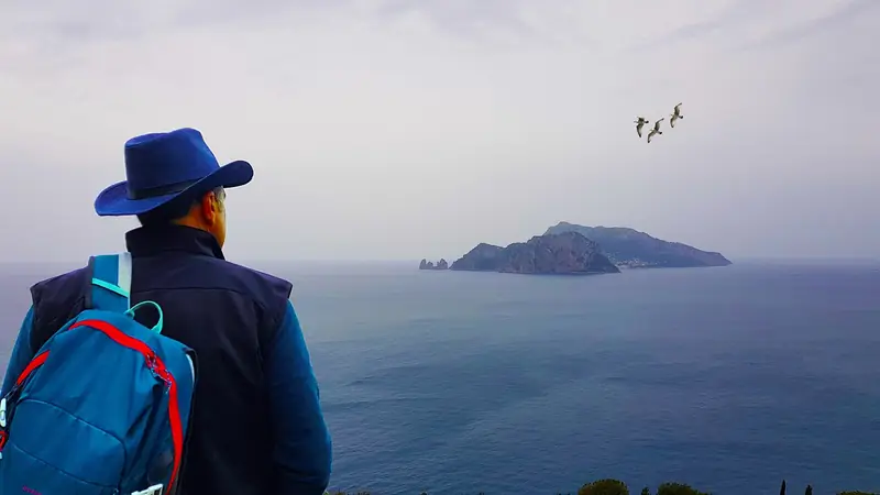 Escursionista che guarda l'isola di Capri dalla costa