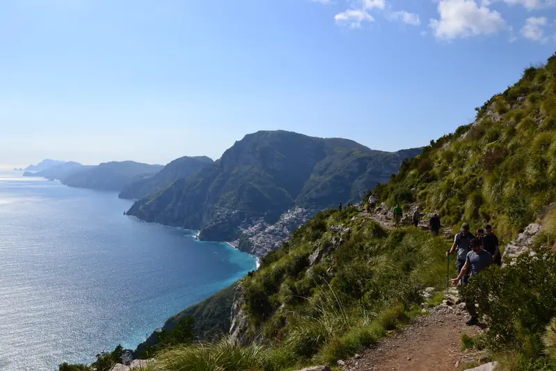 Escursionisti sul Sentiero degli Dei, con la costa verso Positano e il mare sulla sinistra